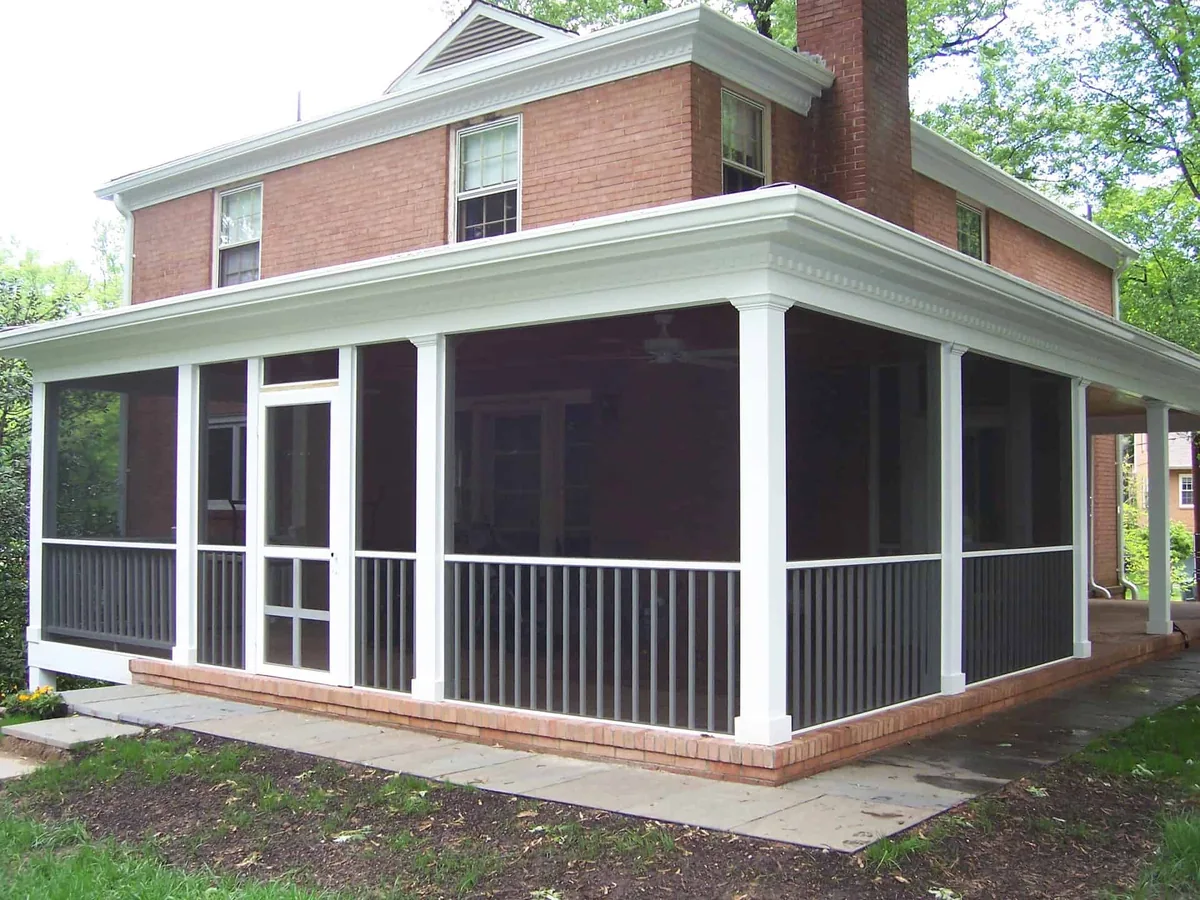 Rescreened wraparound porch with white frames on a brick home.