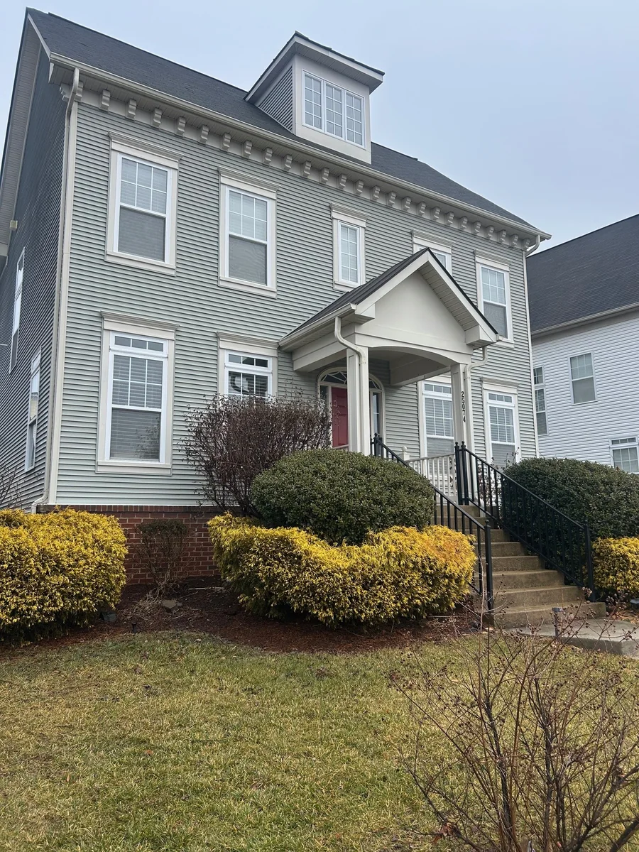 Replacement glass in white-framed double-hung windows on a multi-story home.